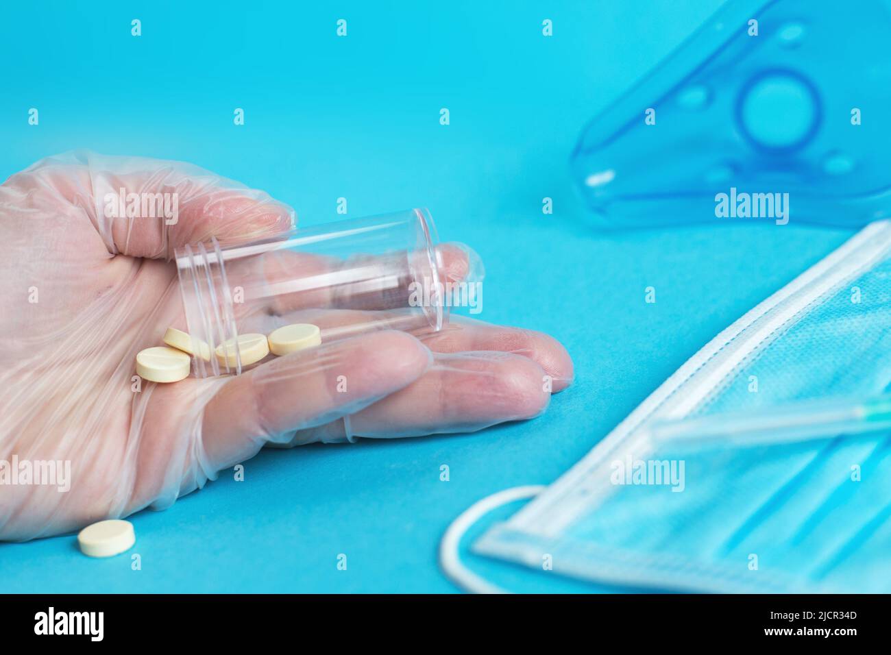 masque médical, seringue et comprimés se ferment sur fond bleu. Coronavirus, grippe, maladie respiratoire concept. Orientation horizontale. Vue de dessus. Banque D'Images