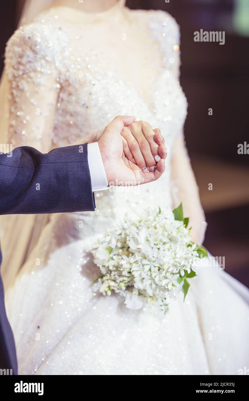 Couple nouvellement wed tenant les mains dans le jour de mariage Banque D'Images