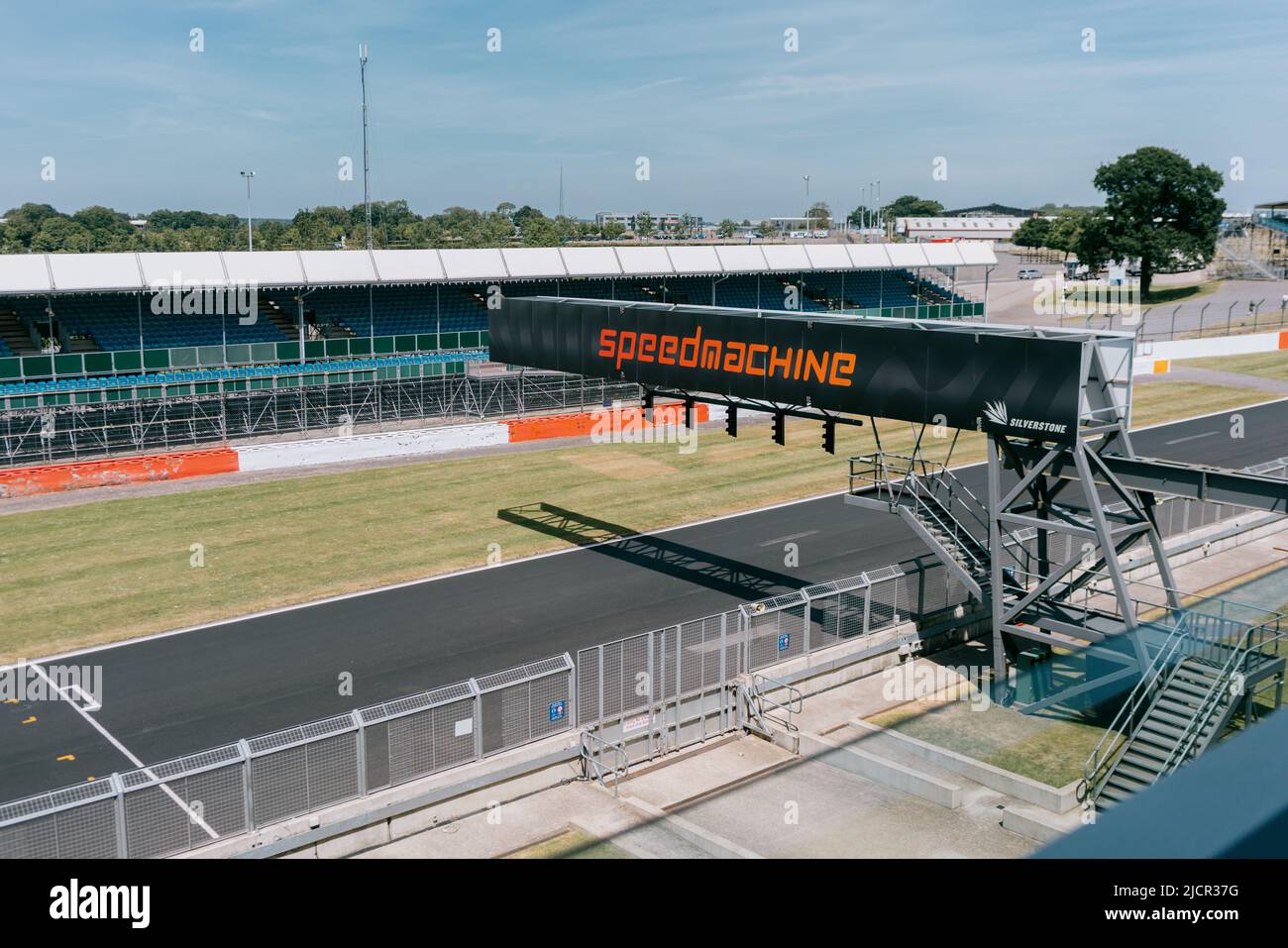 Vue VIP depuis l'aile Silverstone : Hamilton Straight, grille de départ, portique de feux et stands de spectateurs vides. Circuit Silverstone. Speedmachine à travers Banque D'Images