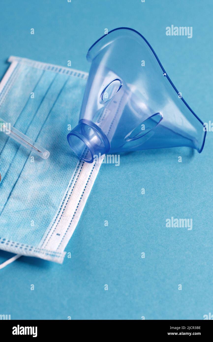 masque médical, seringue et comprimés se ferment sur fond bleu. Coronavirus, grippe, maladie respiratoire concept. Orientation horizontale. Vue de dessus. Banque D'Images