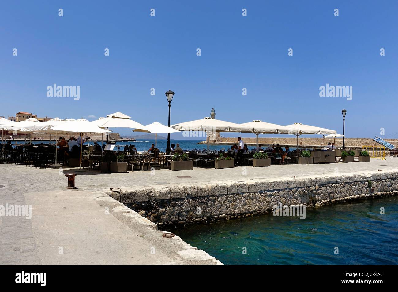 Les touristes mangent dans un restaurant sur le vieux mur du port à Chanie, en Crète Banque D'Images