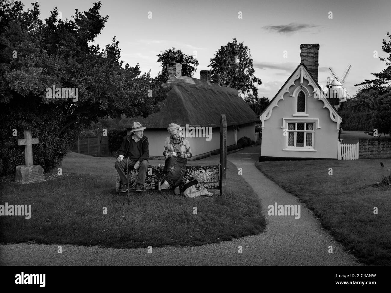 Thaxted Essex UK 11 juin 2022 Homme et femme prenant des réaffectations dans le cimetière de l'église de Thaxted en attendant le festival de Morris de Thaxted en soirée d Banque D'Images