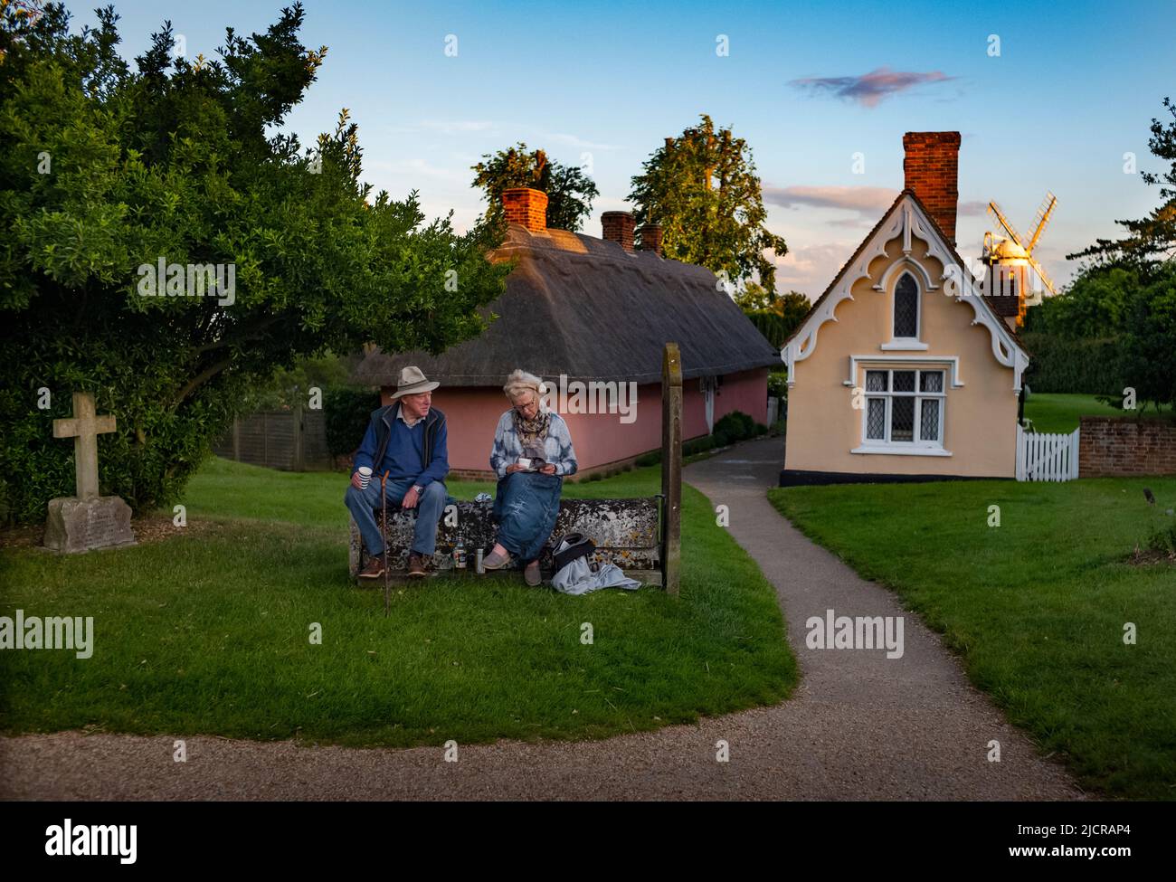 Thaxted Essex UK 11 juin 2022 Homme et femme prenant des réaffectations dans le cimetière de l'église de Thaxted en attendant le festival de Morris de Thaxted en soirée d Banque D'Images