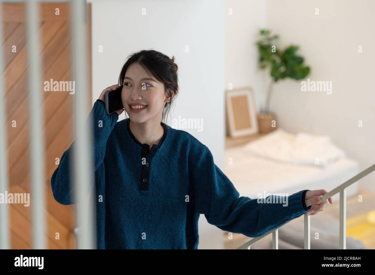 Portrait d'une belle femme asiatique assise dans les escaliers et faisant un appel téléphonique. Banque D'Images