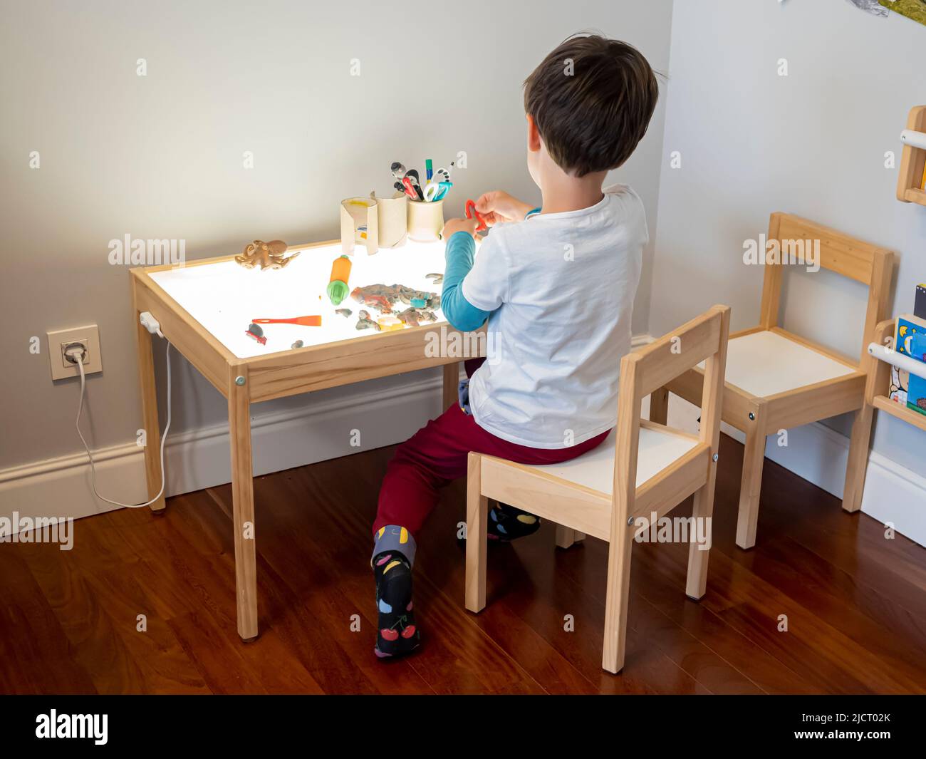 Enfant jouant avec la table lumineuse montessori Banque D'Images