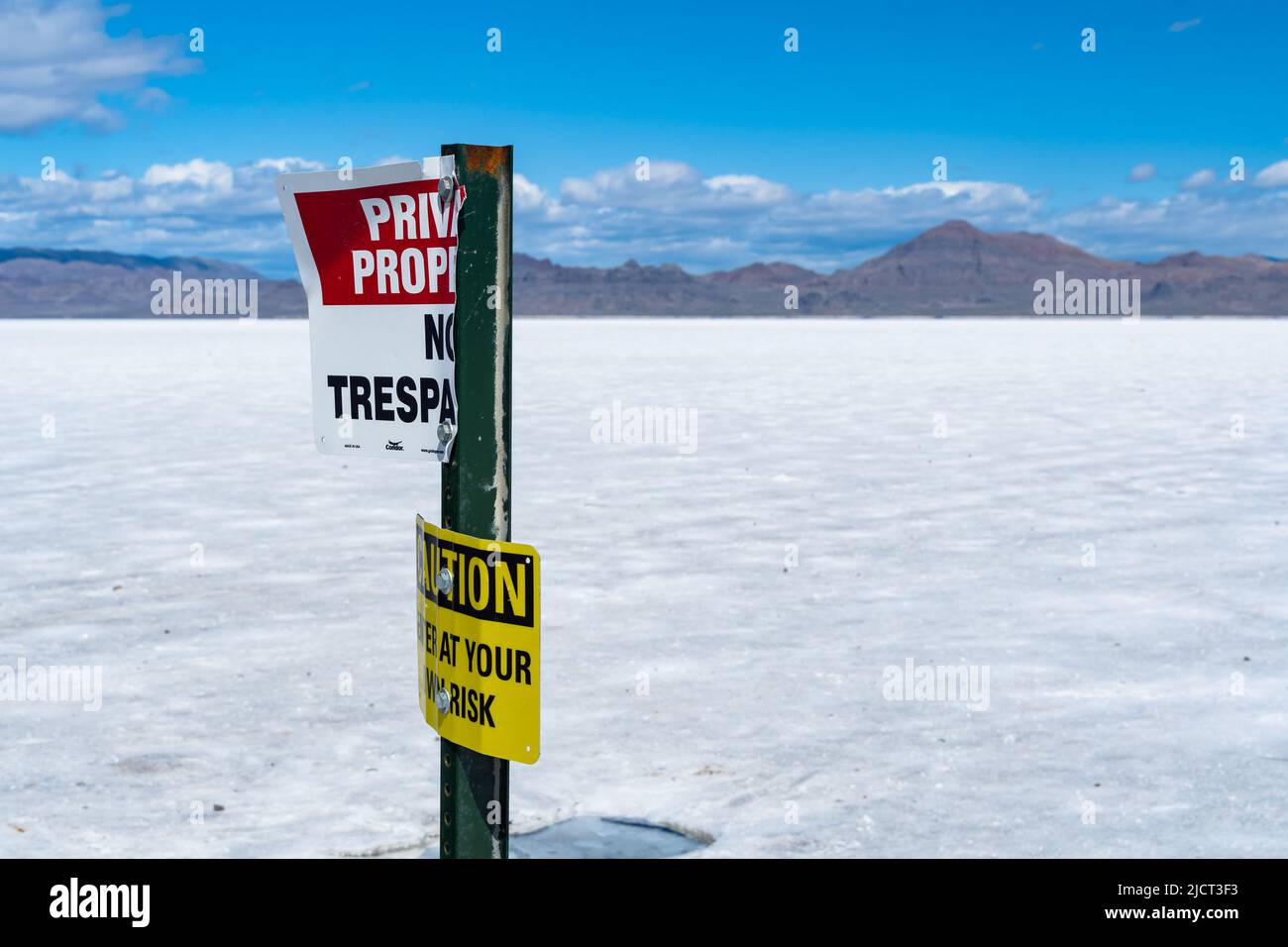 Un vieux et avertir, pas de signe d'intrusion / attention sur les appartements de sel de l'Utah, l'Amérique avec une chaîne de montagnes à l'horizon. Banque D'Images