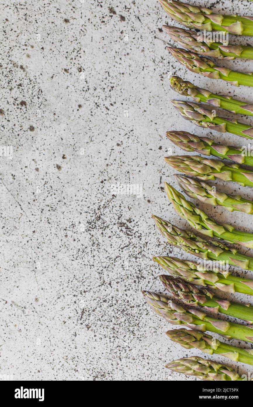 Asperges fraîches. Asperges vertes fraîches crues sur une table rustique en bois Banque D'Images