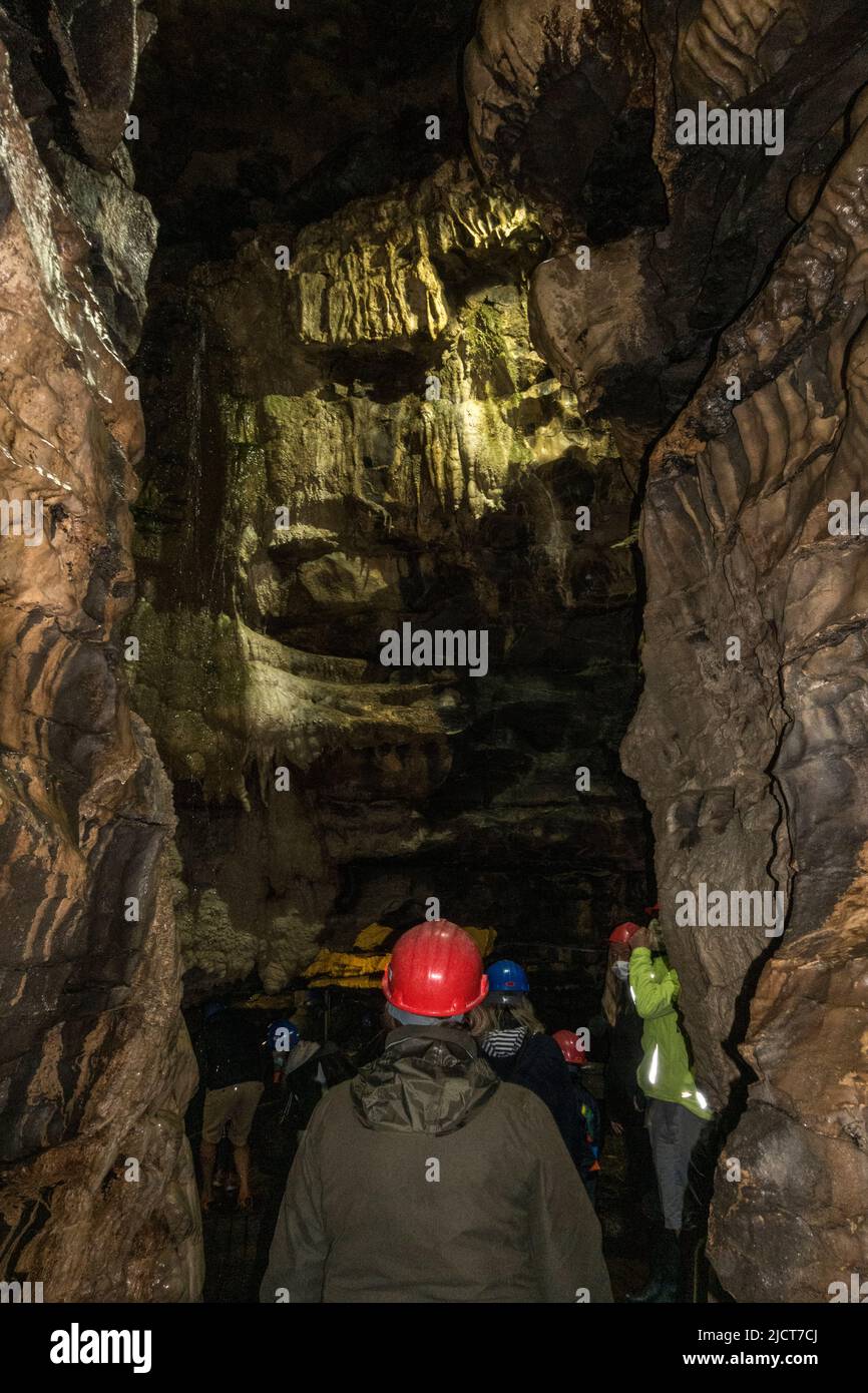 Visiteurs en casques de sécurité dans les superbes grottes de White SCAR à Ingleton, dans le North Yorkshire, en Angleterre. Banque D'Images