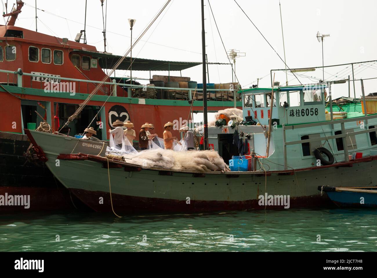 Les pêcheurs tendent leurs filets sur un bateau dans le port d'Aberdeen, à Hong Kong. Banque D'Images