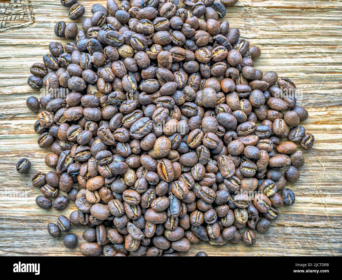 Grains de café de Peaberry rôtis sur une planche en bois Banque D'Images