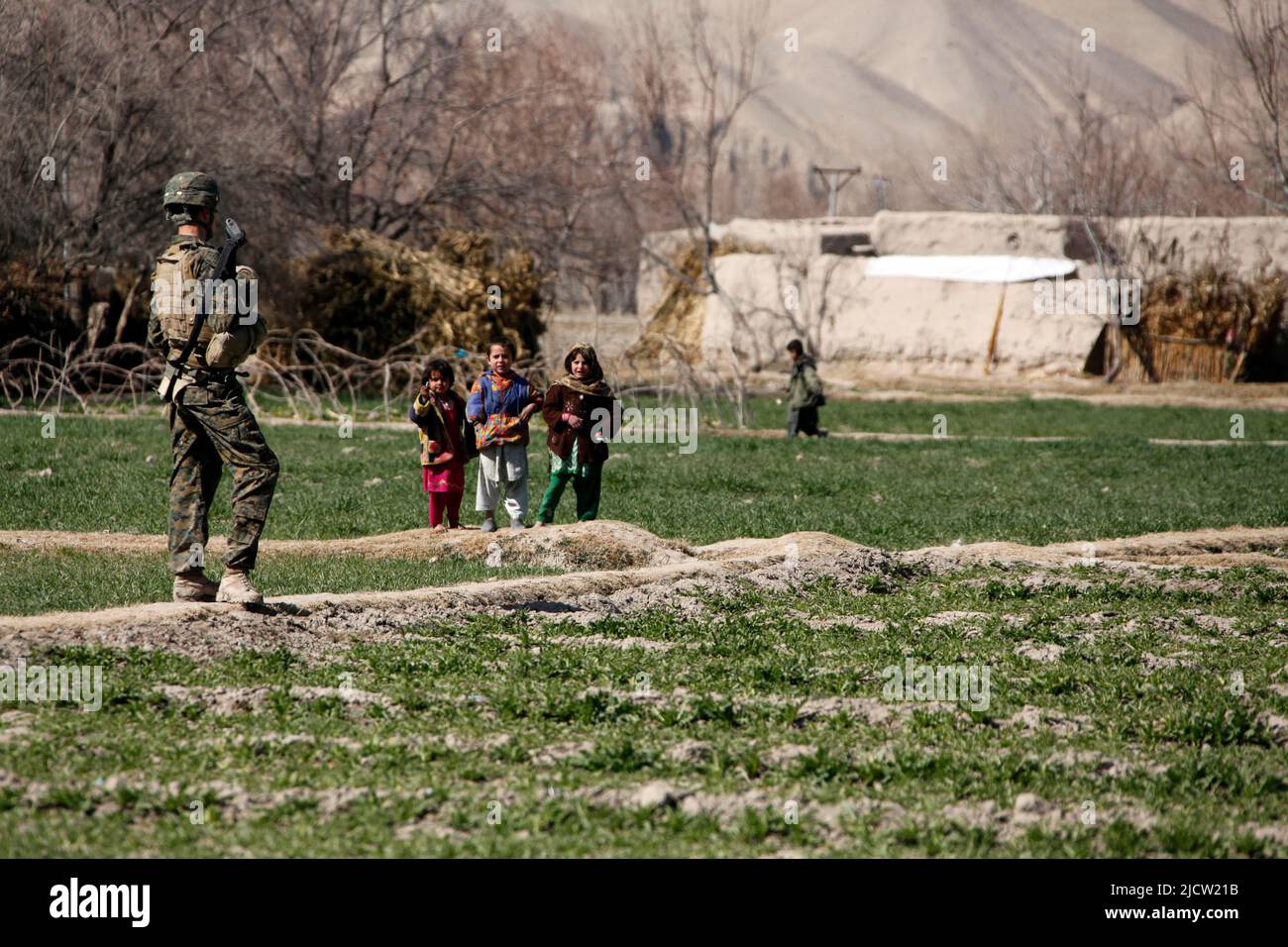 Une Marine américaine avec Bravo Company, 1st Bataillon, 8th Marine Regiment (1/8), équipe de combat régimentaire 6, est suivie par plusieurs enfants afghans qui Banque D'Images