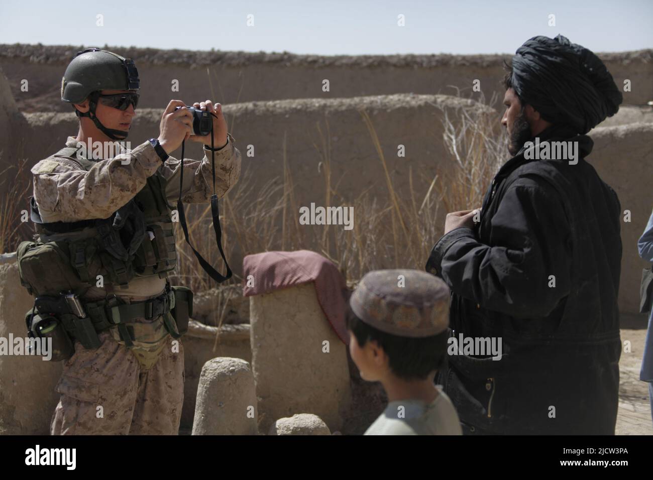 Caporal de lance du commando de la Marine royale britannique Alan Cahill (à gauche) photographie un afghan pour ses enregistrements à Kajaki, province de Helmond, Afghanistan 1 mars Banque D'Images