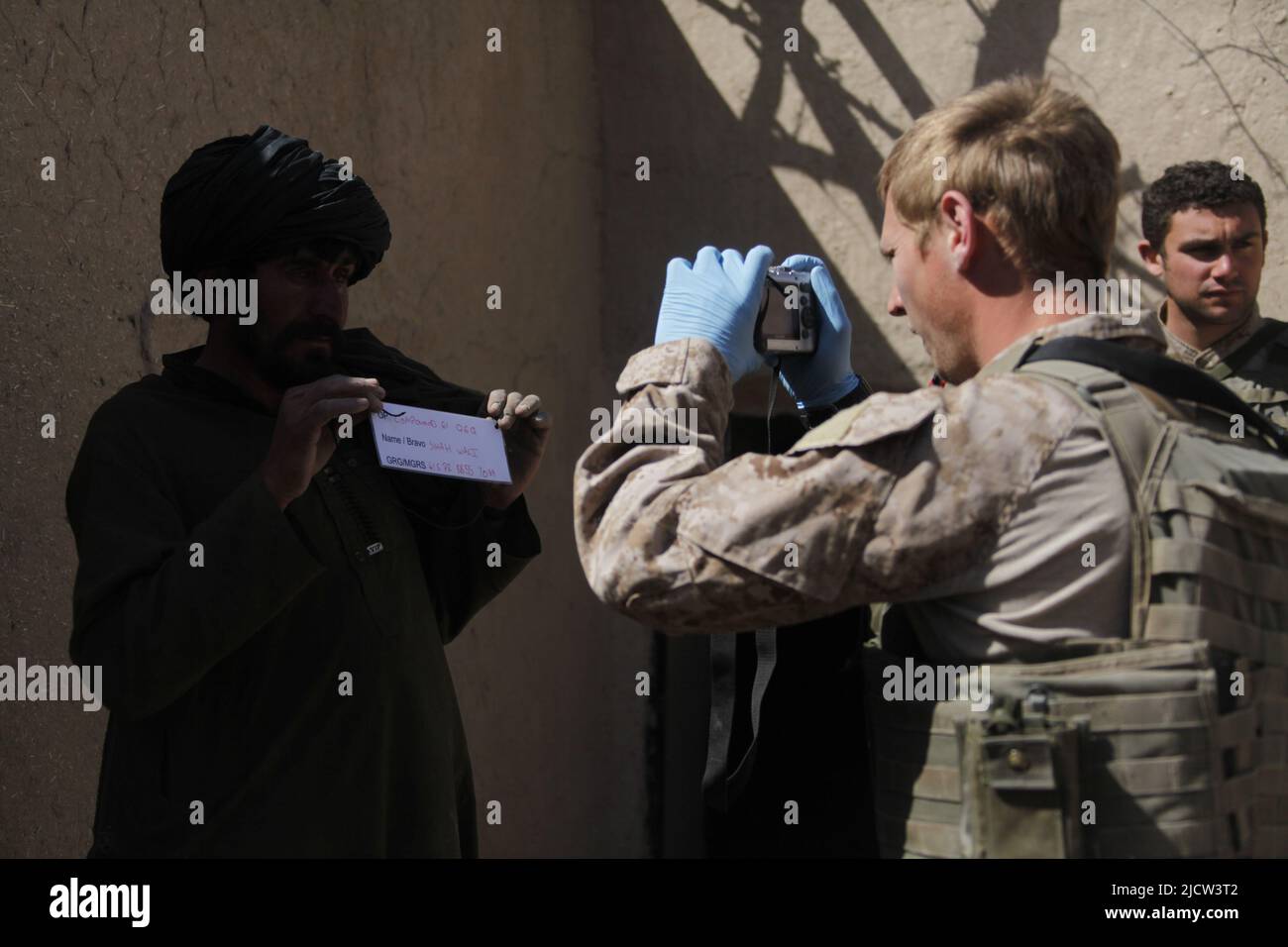 Caporal de lance du commando de la Marine royale britannique Alan Cahill (à gauche) photographie un afghan pour ses enregistrements à Kajaki, province de Helmond, Afghanistan 1 mars Banque D'Images
