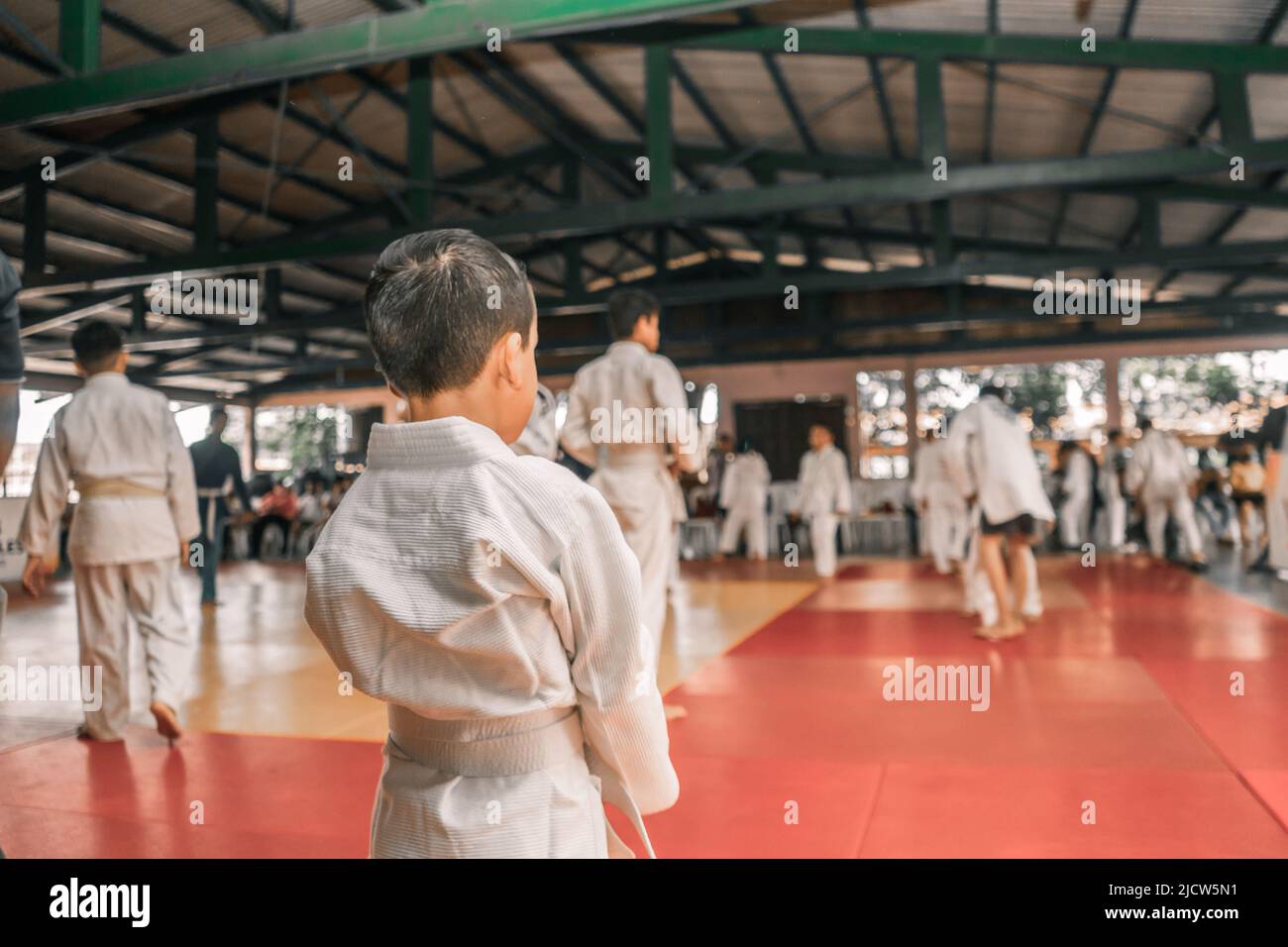 Les enfants Latino vus de derrière sur le point de commencer une pratique de judo dans une salle de gym Banque D'Images