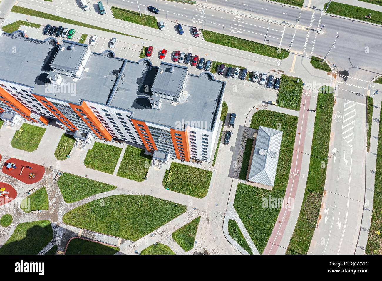 immeuble résidentiel moderne de grande hauteur avec aire de jeux dans la cour et parking près de la façade. photo de drone. Banque D'Images