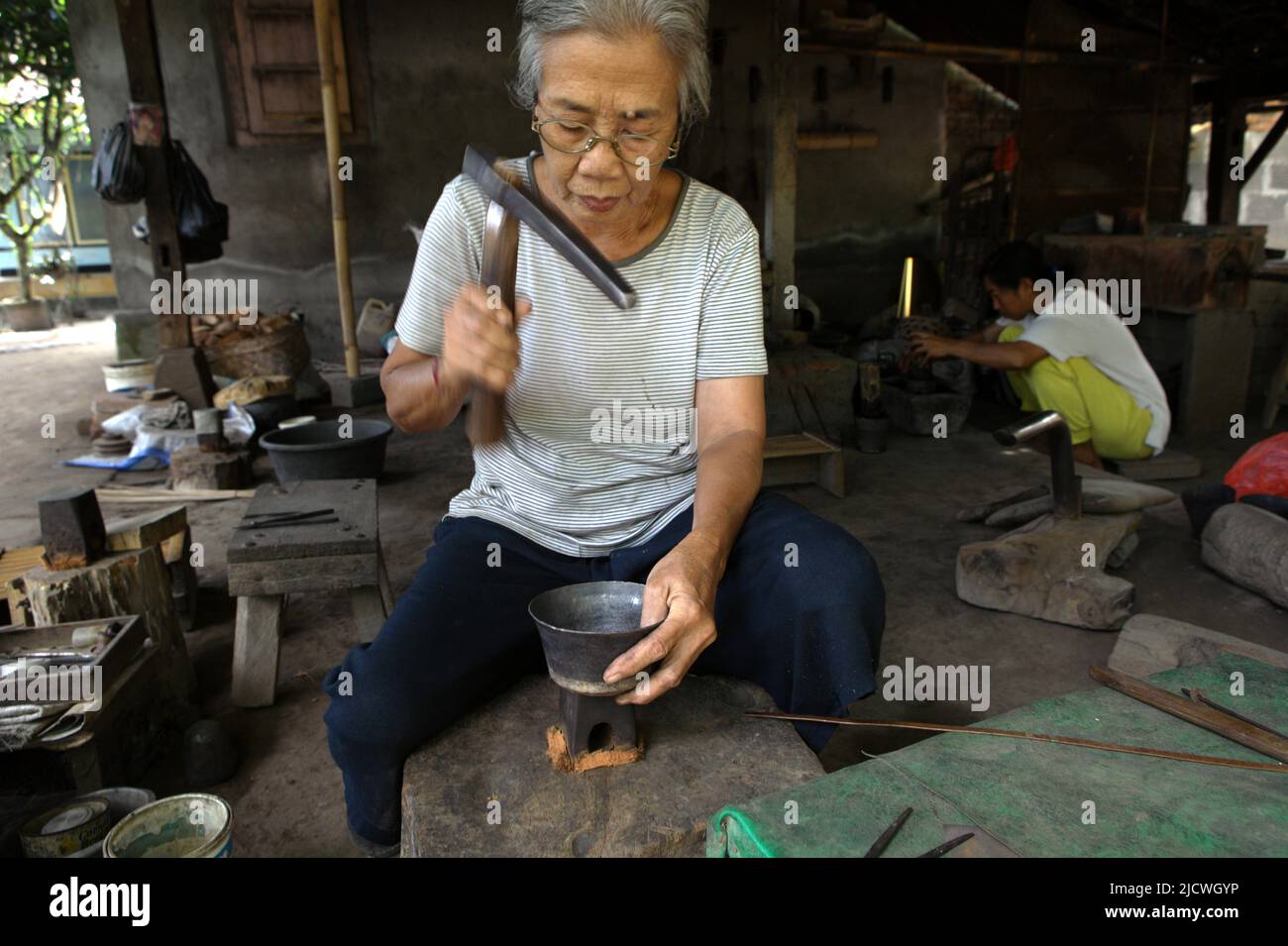 Une femme âgée qui a fait la fabrication d'un argenterie dans un atelier d'argent au village de Kamasan à Klungkung, Bali, Indonésie. Banque D'Images