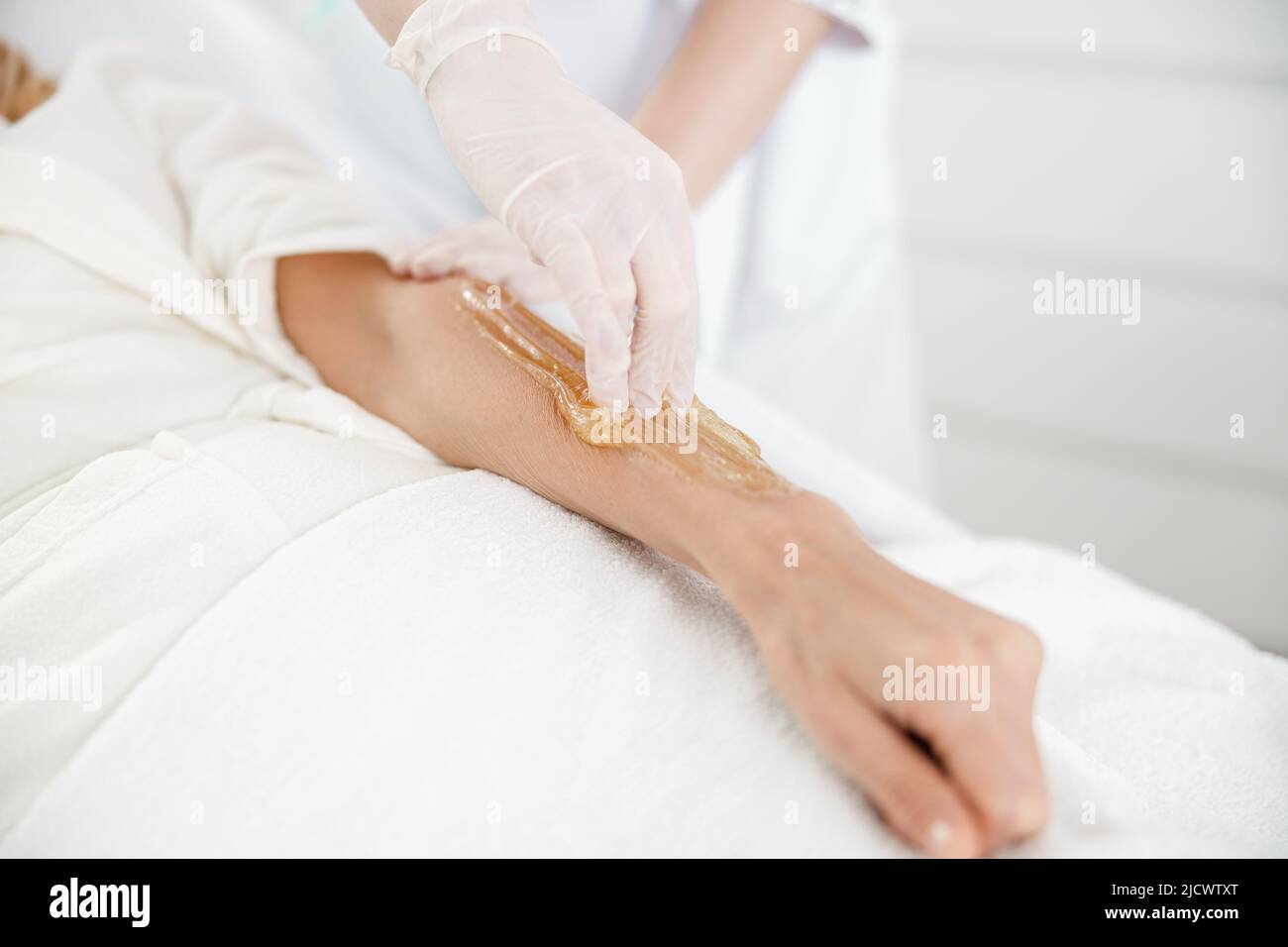 Professionnel fait des cheveux sugaring épilation sur la main femelle dans le centre de cosmétologie Banque D'Images