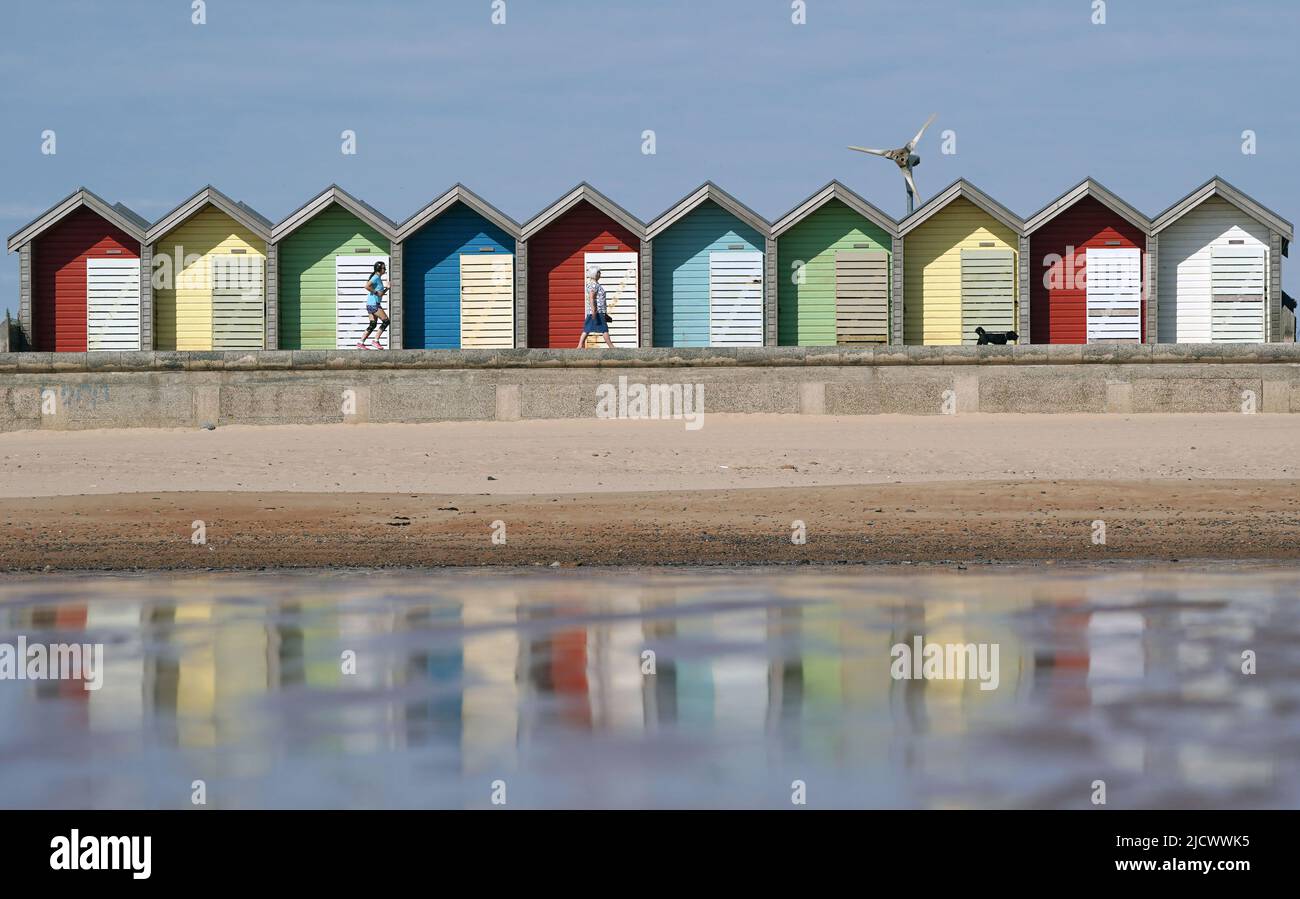 Les gens qui marchent au soleil à Blyth Beach dans Northumberland, sur ce qui est prévu pour être le jour le plus chaud de l'année jusqu'à présent. Date de la photo: Jeudi 16 juin 2022. Banque D'Images