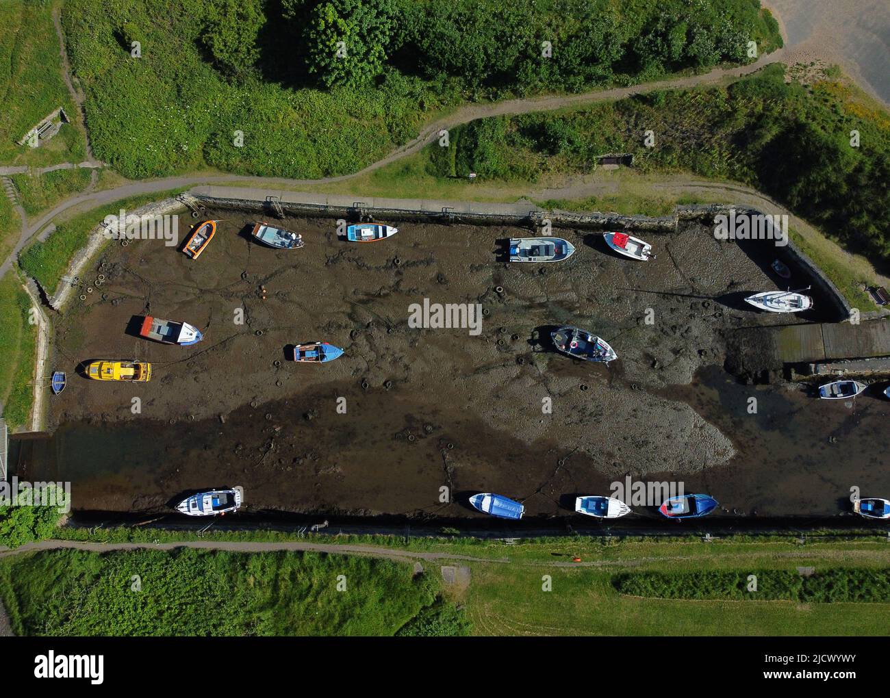 Bateaux à marée basse au port de Seaton Sluice dans Northumberland, sur ce qui devrait être le jour le plus chaud de l'année jusqu'à présent. Date de la photo: Jeudi 16 juin 2022. Banque D'Images