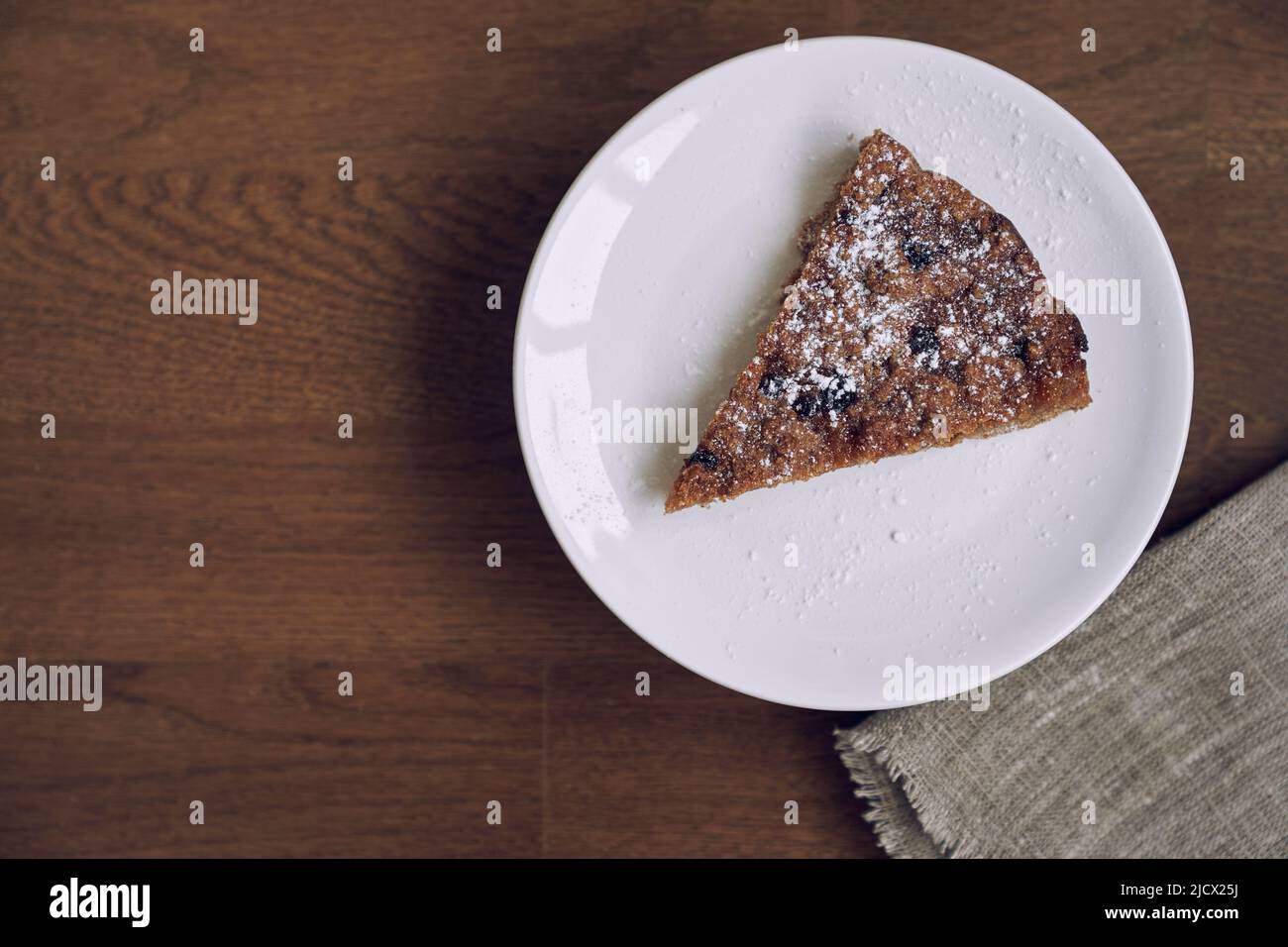 Un délicieux morceau de citronnelle avec des bleuets et des canneberges sans lait et des œufs sur la farine de lin. Une partie de la tarte se trouve sur une plaque blanche sur la table. Une alimentation saine. Photographie de haute qualité Banque D'Images Un délicieux morceau de citronnelle avec des bleuets et des canneberges sans lait et des œufs sur la farine de lin. Une partie de la tarte se trouve sur une plaque blanche sur la table. Une alimentation saine. Photographie de haute qualité Banque D'Images