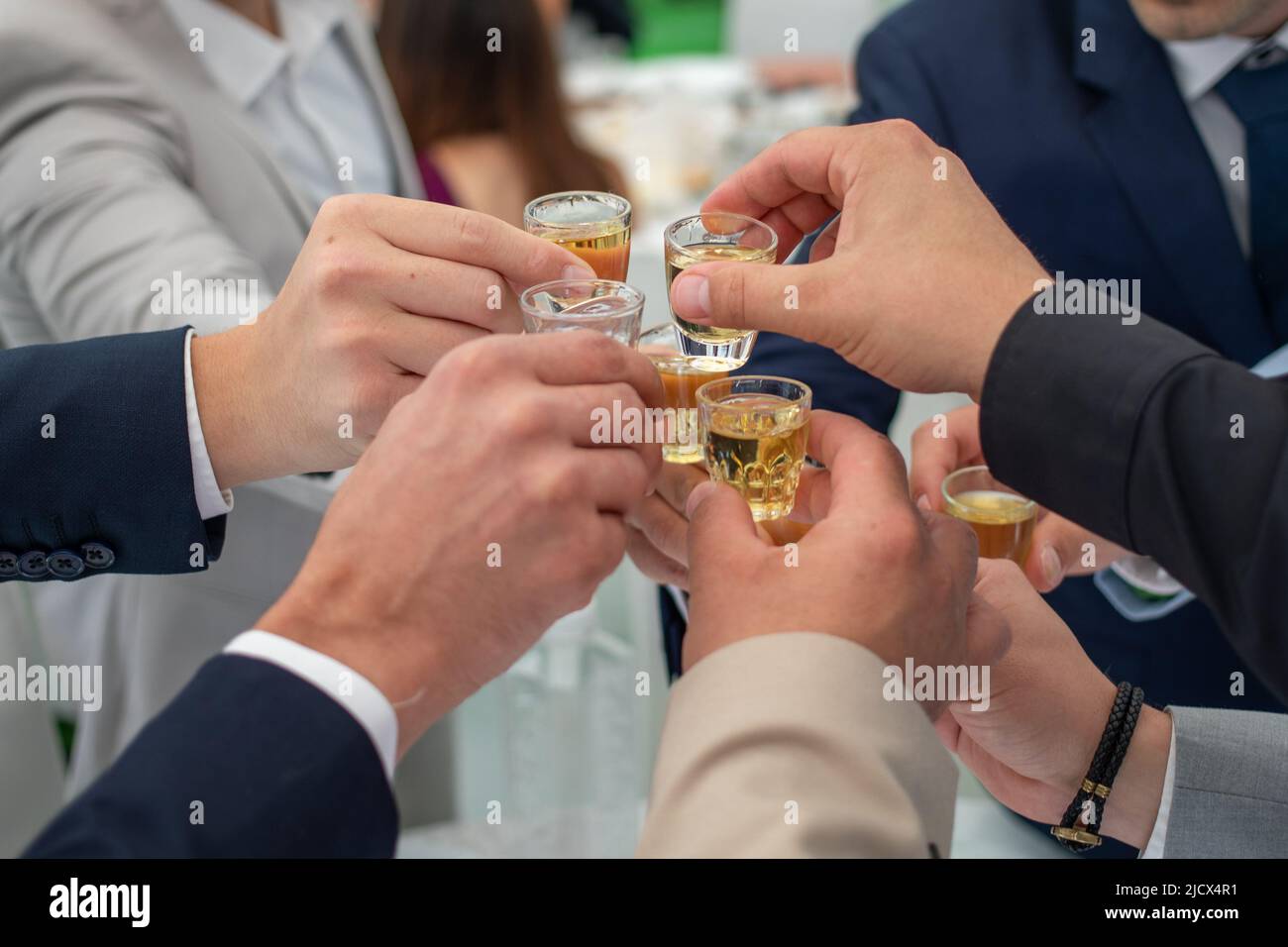 Les amis célèbrent avec rakia brandy lors d'un mariage serbe. Gros plan sur les mains Banque D'Images