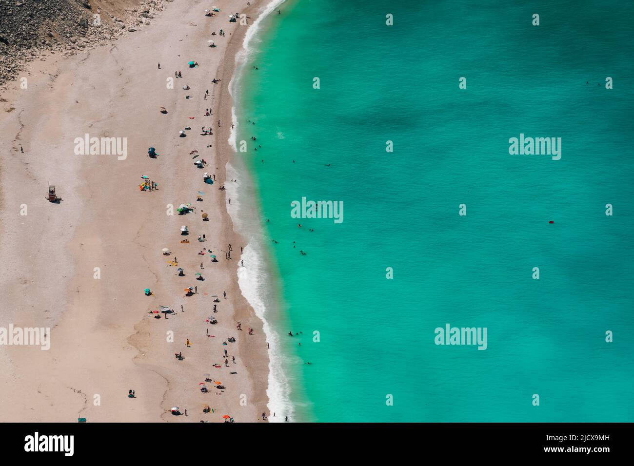 Panorama de plage de Myrtos avec des eaux cristallines et des baigneurs non identifiables, île de Kefalonia, îles grecques, Grèce, Europe Banque D'Images