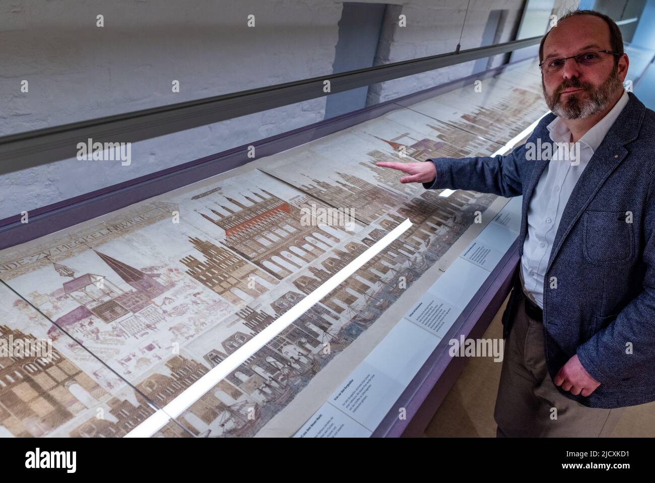 Rostock, Allemagne. 16th juin 2022. Le directeur du musée Steffen Stuth se trouve en face de l'escadre de 19 mètres de long de Vicke Schorler dans le musée d'histoire culturelle, qui est à nouveau exposé après une restauration complète. Le défilement de l'image de l'épicier et artiste de Rostock, Vicke Schorler, vieux de plus de 444 ans, est rarement montré. Pour la première fois en douze ans, la vue historique de la ville de 19 mètres sera présentée pendant une semaine. La vue de Rostock est très sensible à la lumière en raison de son âge et est donc rarement présentée. Credit: Jens Büttner/dpa/Alay Live News Banque D'Images