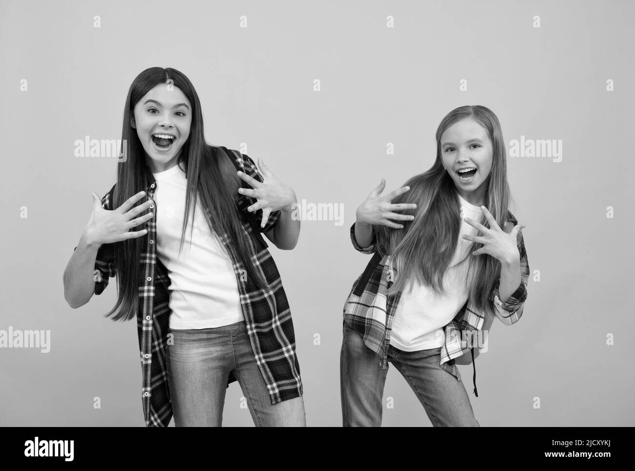 joyeux drôle adolescentes dans décontracté damier chemise porter sac à dos, l'amusement d'école Banque D'Images