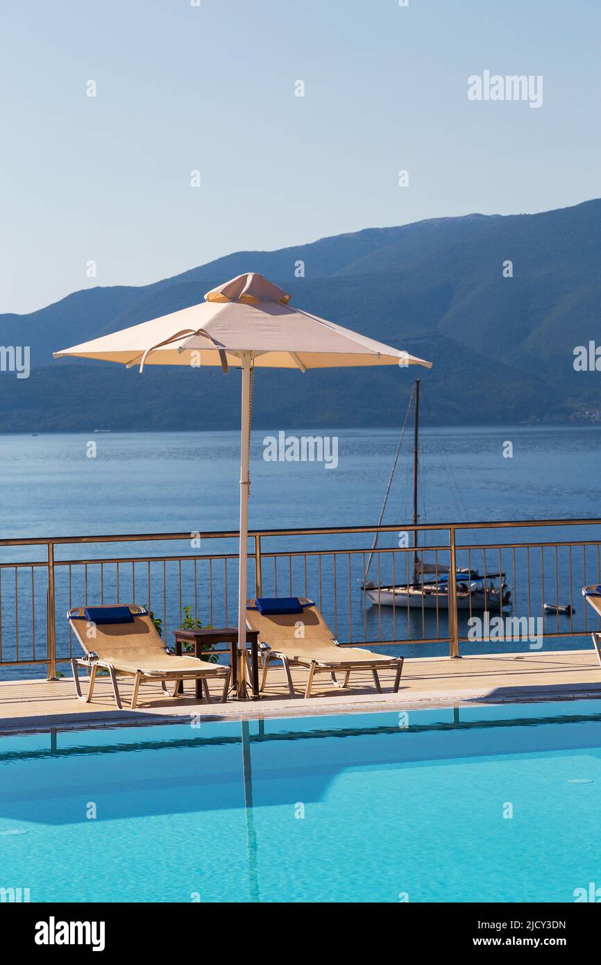 Piscine de luxe avec chaises longues vides et parasol au Resort avec belle vue sur la mer. Banque D'Images