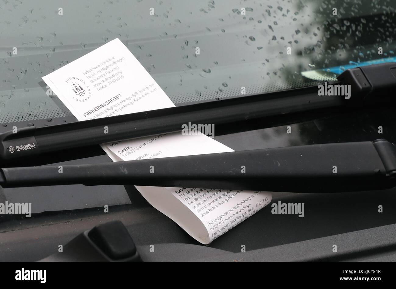 Copenhague, Danemark - 14 juin 2022 : vue rapprochée d'une amende de stationnement fixée à l'essuie-glace de la vheicle. Banque D'Images Copenhague, Danemark - 14 juin 2022 : vue rapprochée d'une amende de stationnement fixée à l'essuie-glace de la vheicle. Banque D'Images