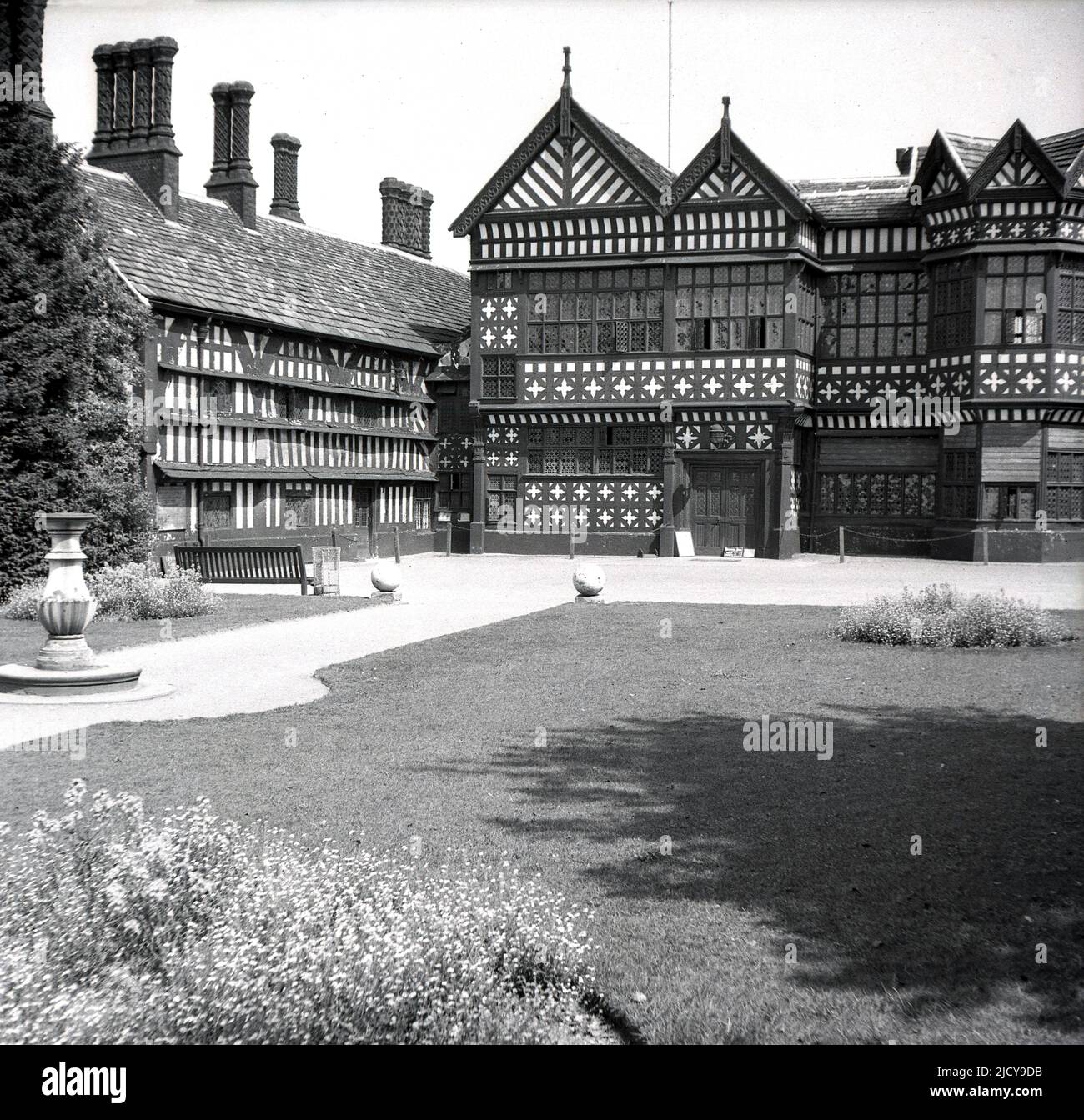 Années 1940, historique, une vue de Bramall Hall, Bramhall Stockport, Angleterre, Royaume-Uni. Un manoir Tudor à pans de bois qui remonte au XIVe siècle, avec des ajouts ultérieurs, la maison et le parc environnant ont été acquis par les autorités locales en 1935 et sont devenus un musée. La famille Davenport, qui aurait construit la maison, a tenu le manoir pendant plus de 500 ans. Ici, nous voyons une vue des années 1940 depuis l'ouest, de l'entrée principale, de la cour, de l'aile sud et du Grand Hall au centre. Banque D'Images