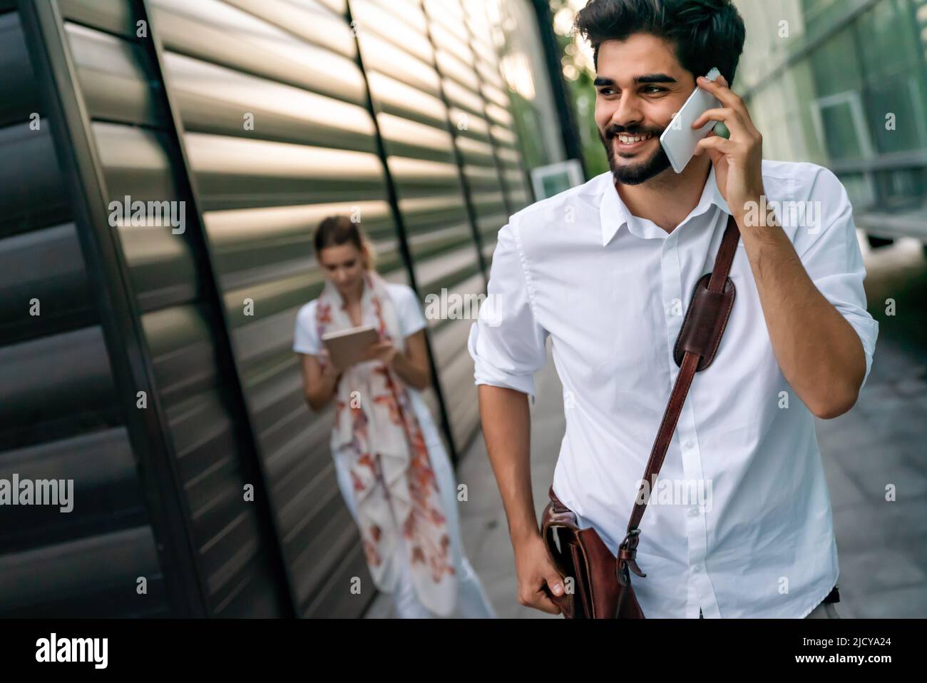 Portrait de jeunes gens d'affaires joyeux et heureux qui parlent, qui marchent à l'extérieur Banque D'Images