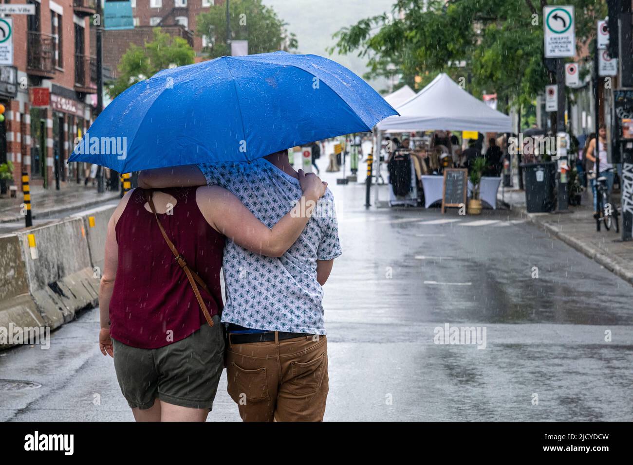 Montréal, CA - 12 juin 2022 : personnes sur l'avenue Mont-Royal tenant un parapluie sous la pluie et la tempête Banque D'Images