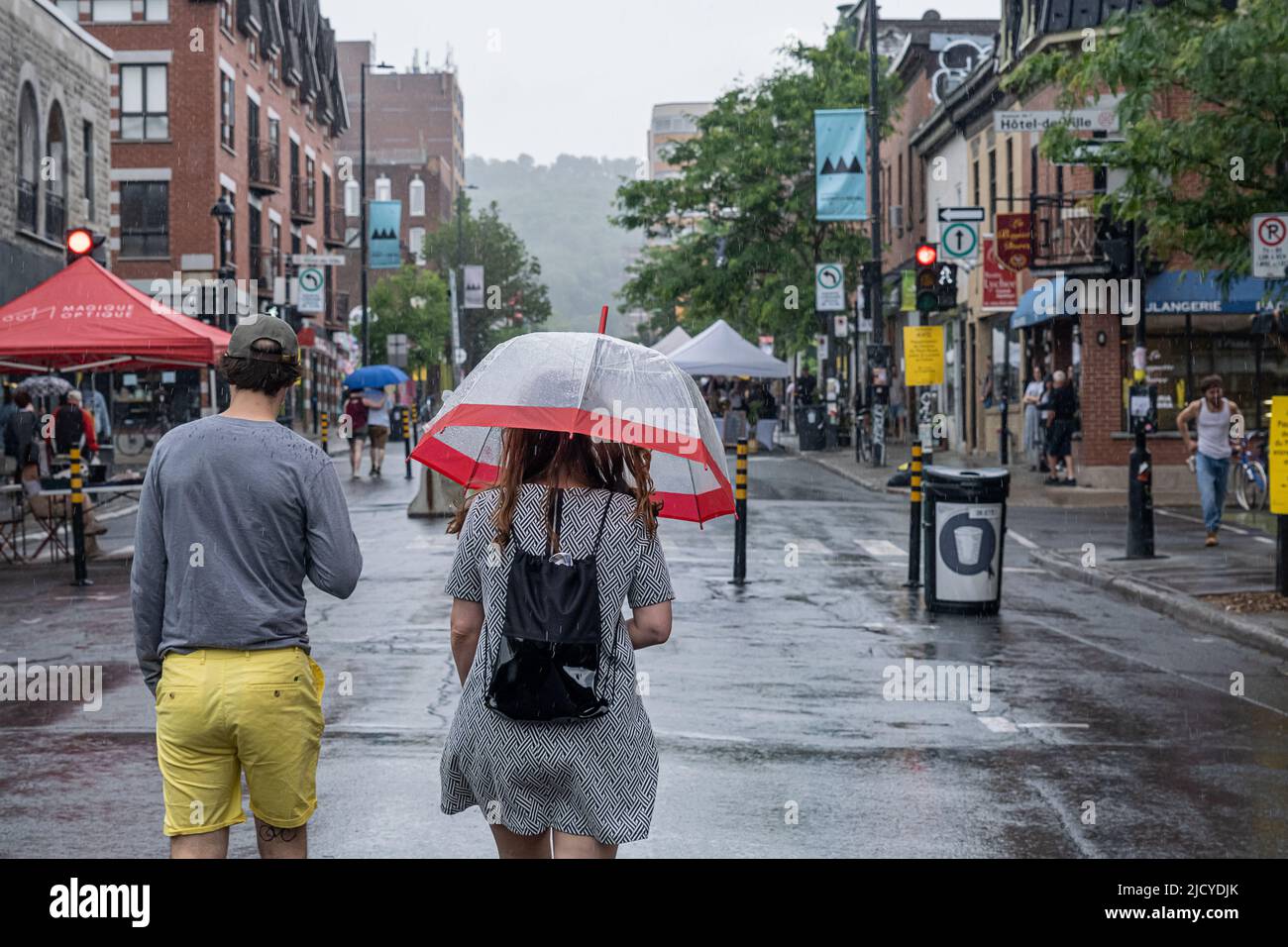 Montréal, CA - 12 juin 2022 : personnes sur l'avenue Mont-Royal tenant un parapluie sous la pluie et la tempête Banque D'Images