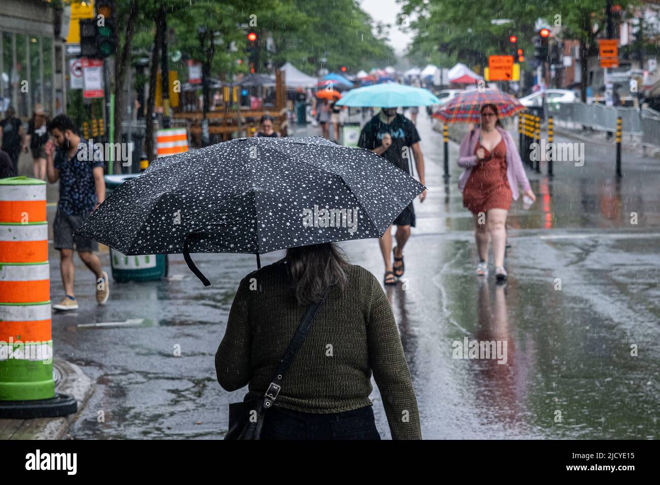 Montréal, CA - 12 juin 2022 : personnes sur l'avenue Mont-Royal tenant un parapluie sous la pluie et la tempête Banque D'Images
