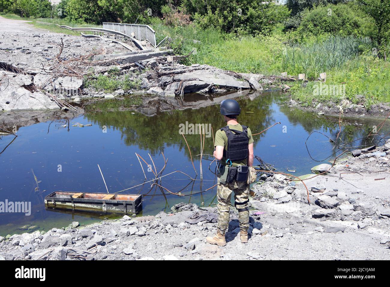 RÉGION DE KHARKIV, UKRAINE - le 16 JUIN 2022 - Un soldat regarde un pont qui s'est ouvert le long de l'autoroute Belgorod 20km au large de la frontière entre l'Ukraine et la Russie, Kharkiv Banque D'Images