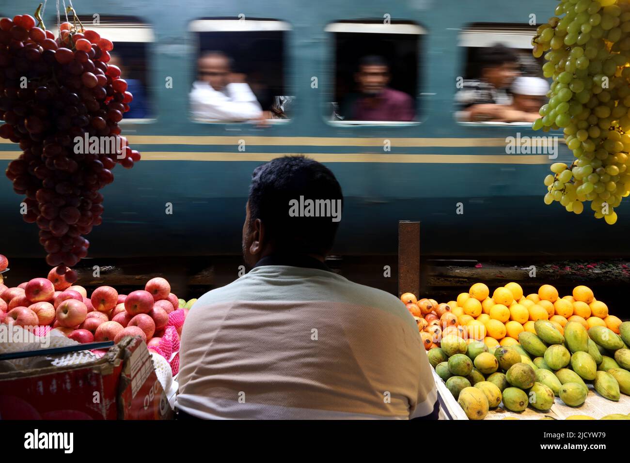 Dhaka, Dhaka, Bangladesh. 16th juin 2022. Un train de banlieue passant par le marché Jurain Railgate. Les gens qui vendent des fruits et des légumes à quelques centimètres de la rame. Deux trains traversent ce marché à une vitesse d'environ 30 kilomètres à l'heure. (Credit image: © Syed Mahabubul Kader/ZUMA Press Wire) Banque D'Images