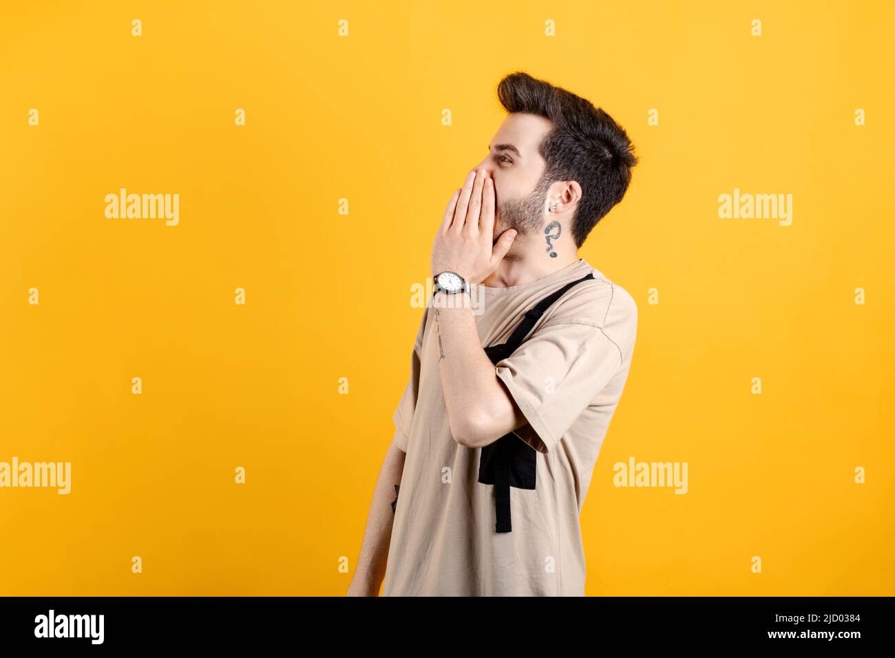 Homme caucasien portant un t-shirt beige posant isolé sur fond jaune criant et criant fort à côté avec la main sur la bouche. Concept de communication. Banque D'Images