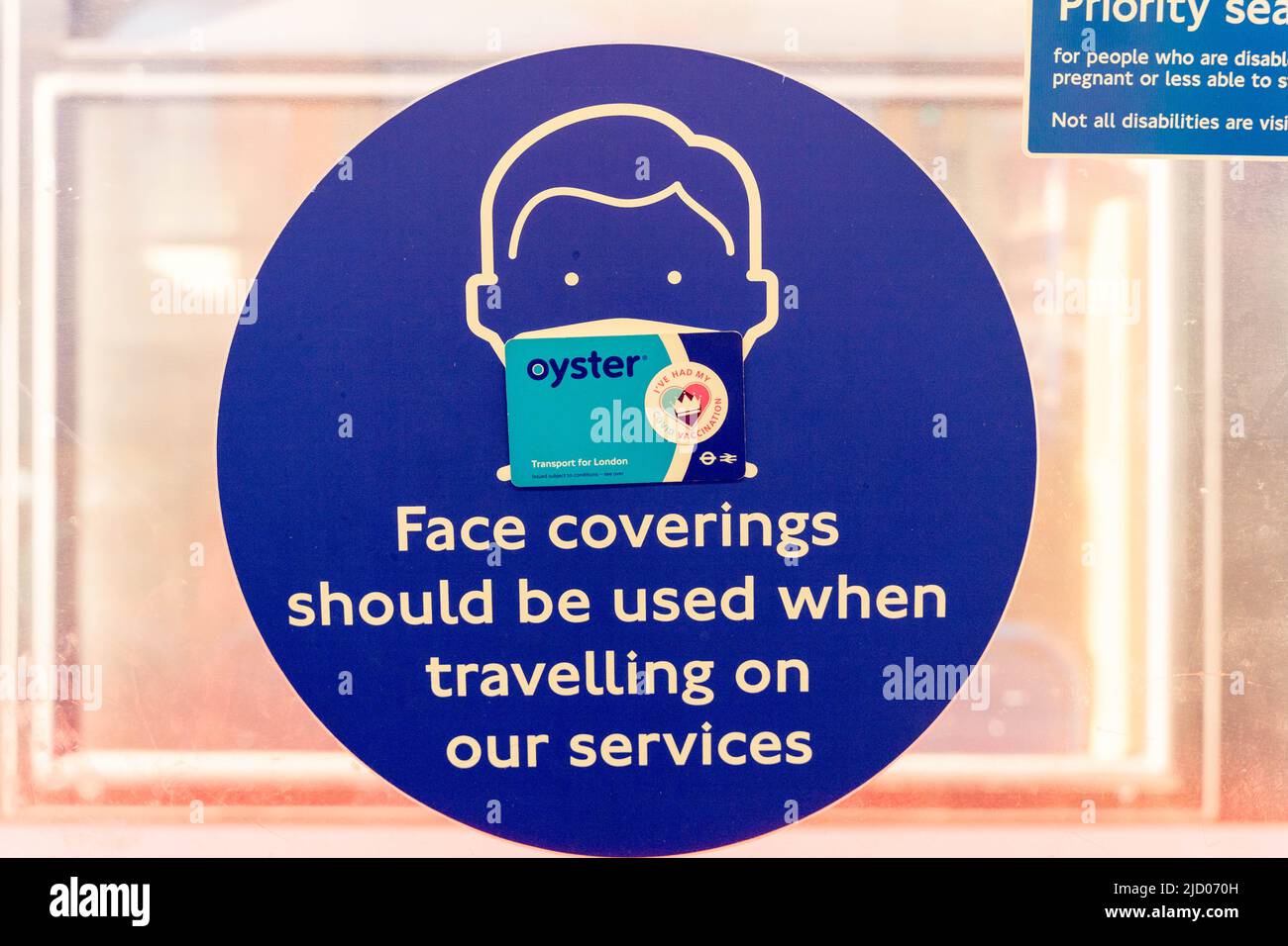 Carte d'huîtres bleues avec un autocollant « J'ai eu mes vaccins » sur une affiche indiquant que « les revêtements de visage doivent être utilisés lors des déplacements sur nos services » TFL Banque D'Images