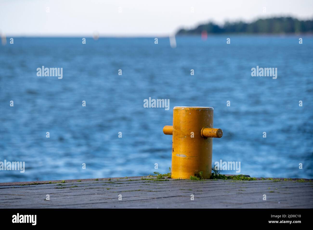Helsinki / Finlande - 15 JUIN 2022 : gros plan d'un bollard amarré contre une mer bleu vif. Une petite île à l'horizon. Banque D'Images