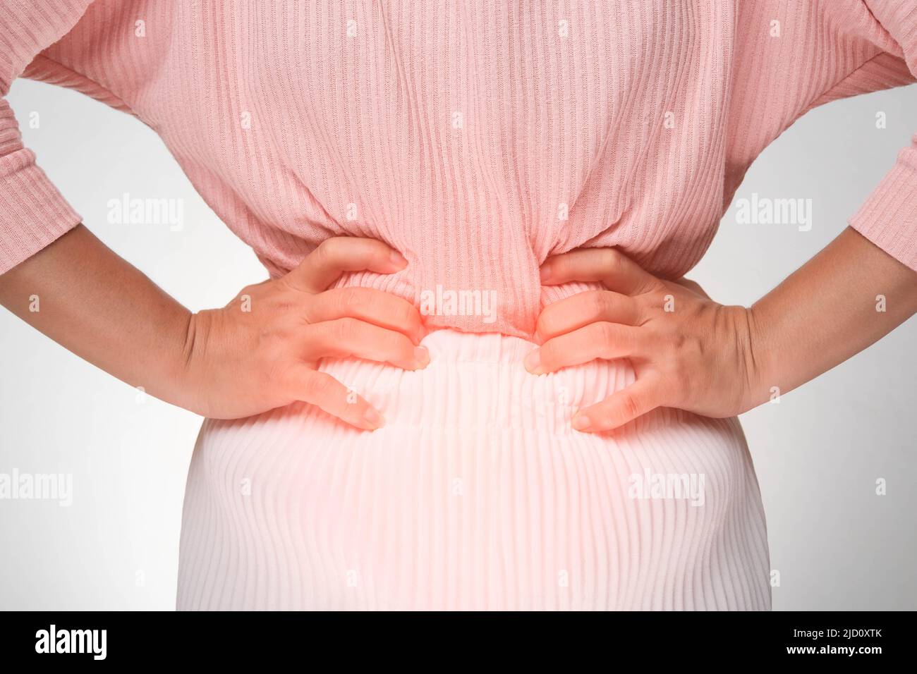 Femme tenant les mains sur l'estomac avec des douleurs menstruelles, des douleurs abdominales, des maux d'estomac, une intoxication alimentaire sur fond blanc. Gros plan. Problèmes de santé Banque D'Images