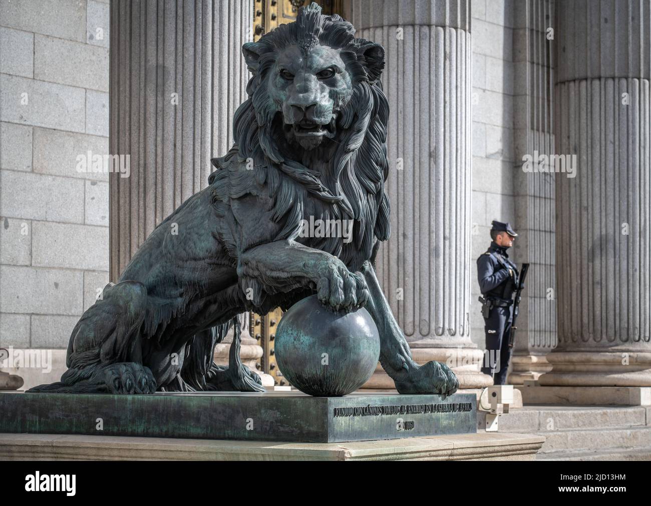Garde armée debout près d'une statue de lion à l'extérieur du Palacio de las Cortes, Madrid, Espagne Banque D'Images