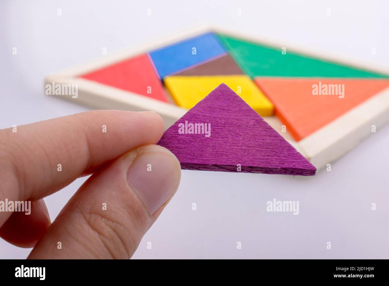 Main tenant une pièce manquante dans un puzzle en forme de tangram Banque D'Images