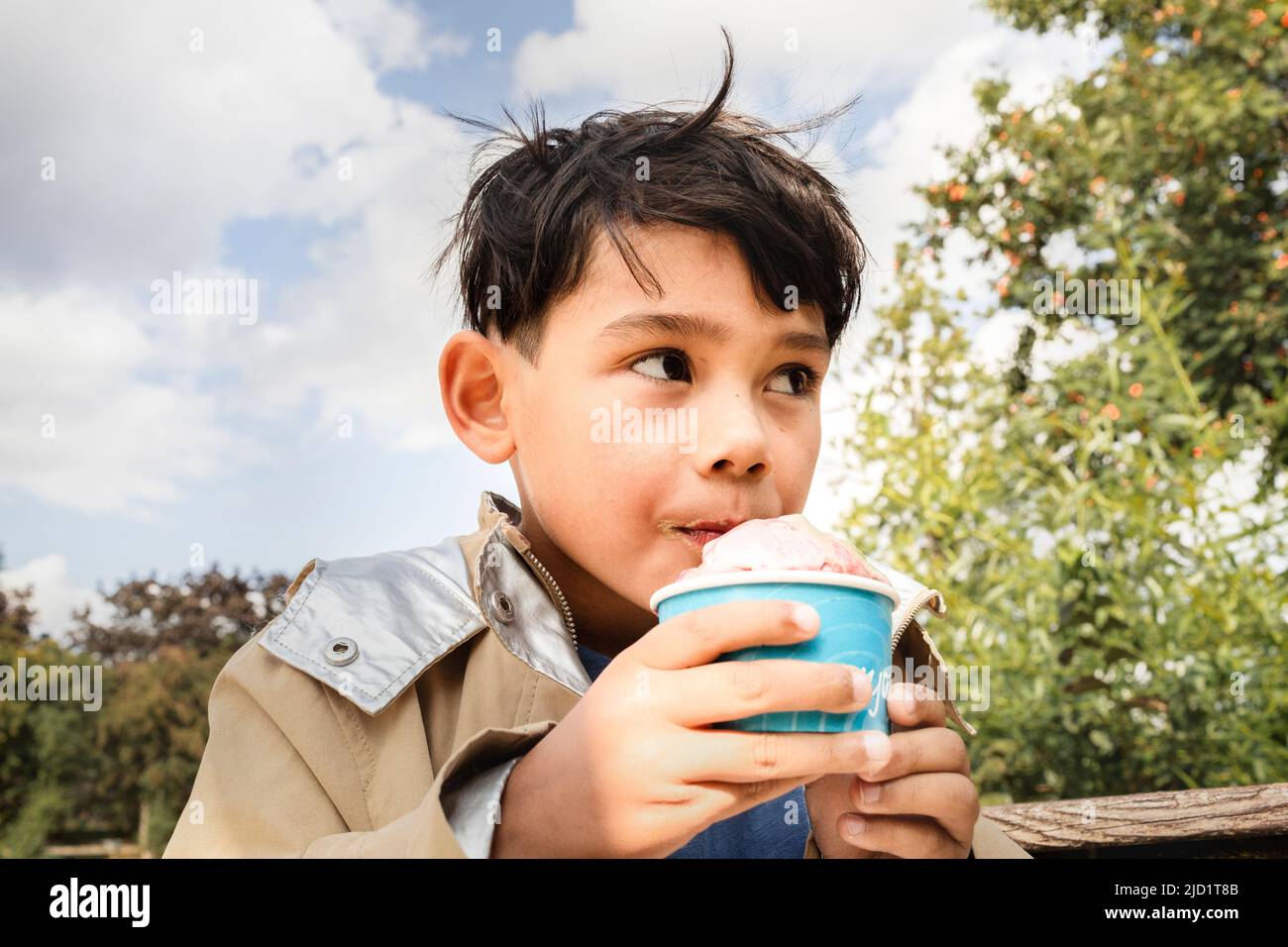 Un garçon mange de la glace de la tasse Banque D'Images