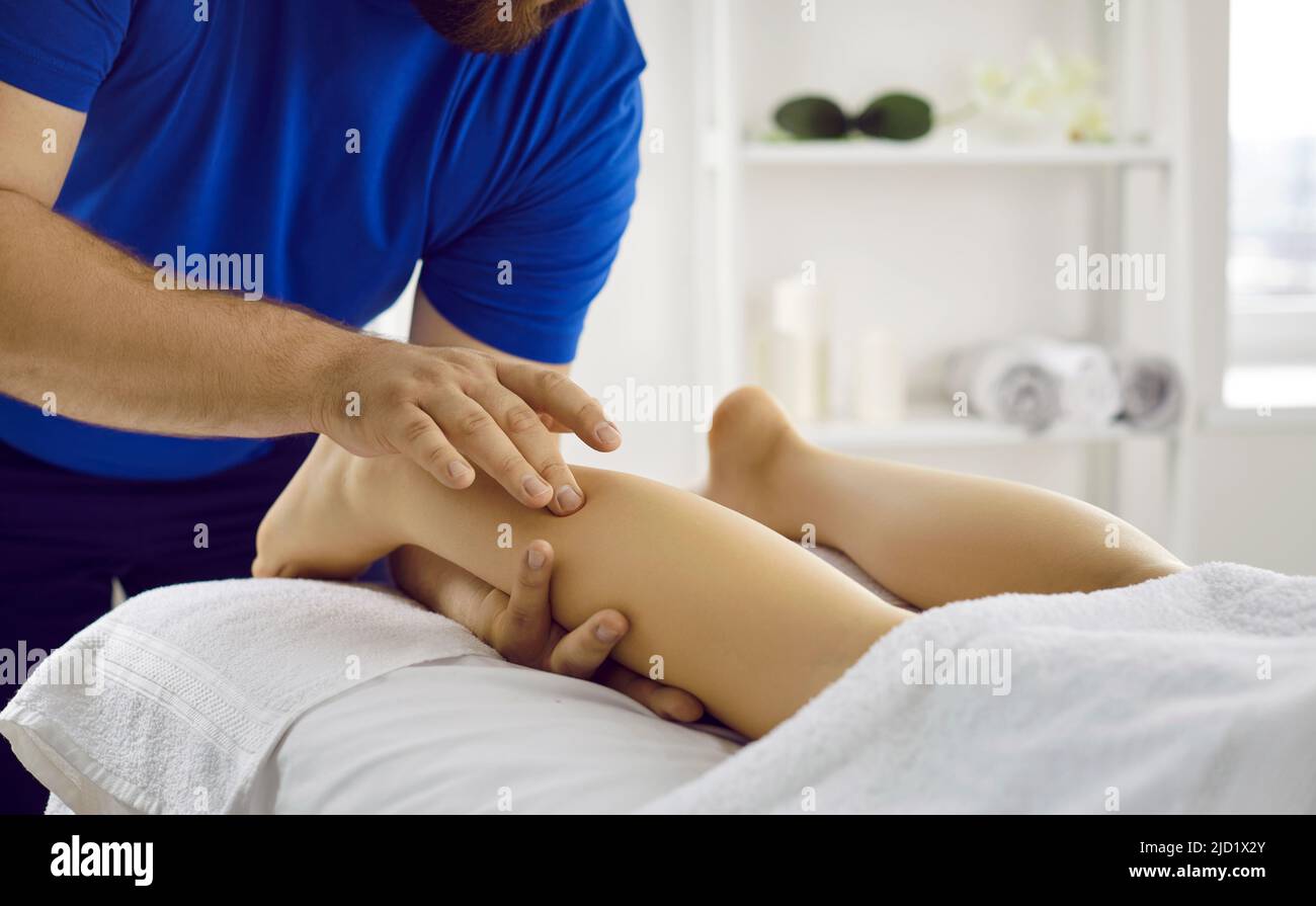Masseur professionnel, physiothérapeute, ostéopathe ou chiropraticien faisant des massages de jambes Banque D'Images