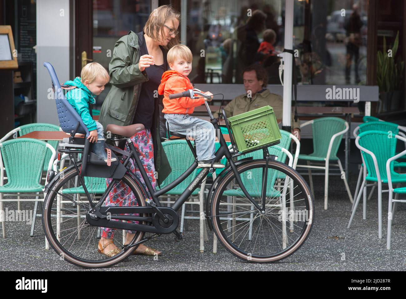 Amsterdam, Hollande: Une jeune mère place ses deux jeunes enfants dans les sièges de son vélo à Rentre à la maison. Banque D'Images