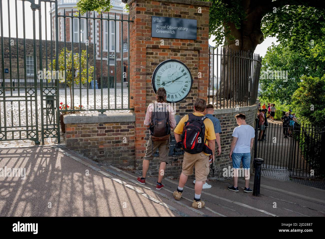 Les visiteurs de l'Observatoire royal inspectent l'horloge de la porte au Greenwich Meridian à Greenwich Park, le 16th juin 2022, à Londres, en Angleterre. Greenwich Park est un ancien parc de chasse et l'un des plus grands espaces verts du sud-est de Londres. Banque D'Images