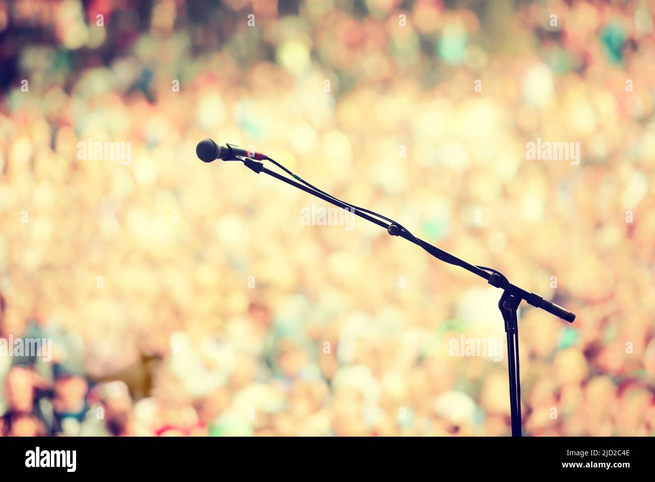 Prêt à faire du rock. Un microphone sur un stand sur une scène vide avec le public en arrière-plan. Banque D'Images