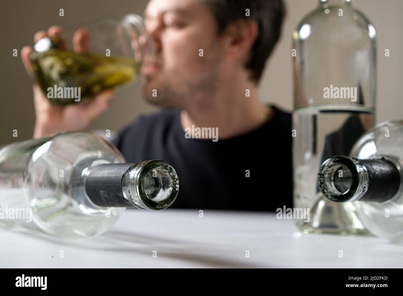 Un homme qui a une dépendance à l'alcool boit de la saumure dans un pot de concombres de taupe, un homme dans une gueule. Banque D'Images