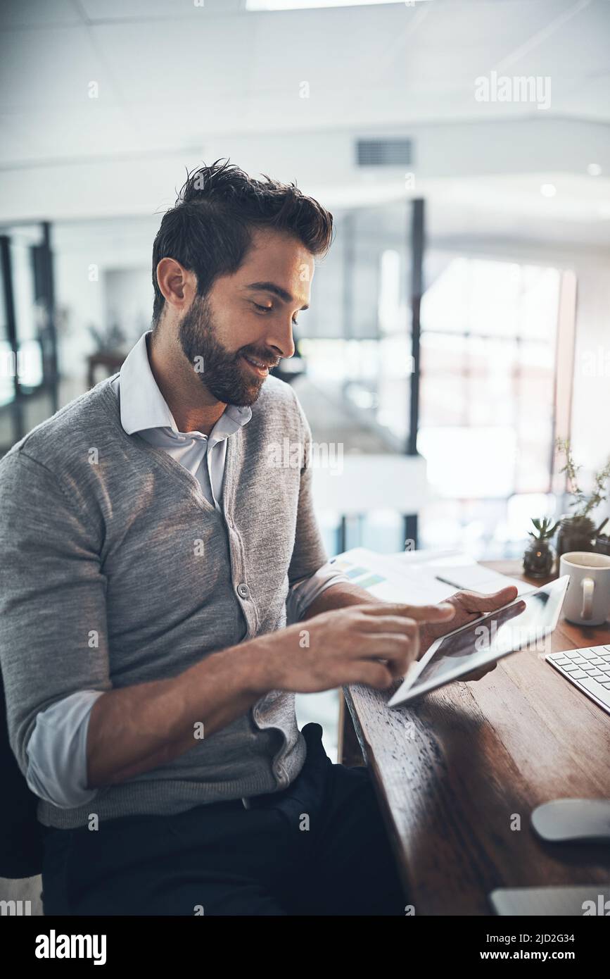 Son outil le plus pratique. Photo d'un jeune homme d'affaires travaillant sur une tablette numérique dans un bureau. Banque D'Images